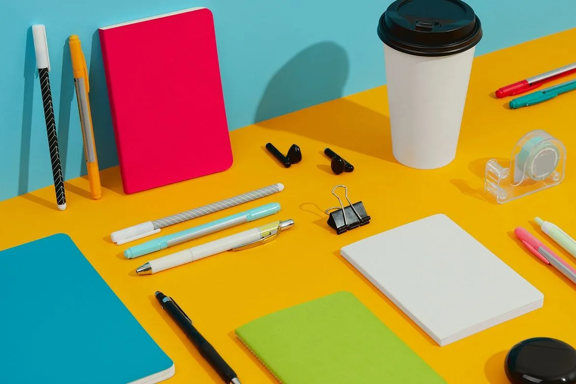 colorful notepads pens and paper cup on orange ta 2021 09 03 15 31 53 utc
